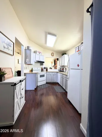 a open kitchen with cabinets a refrigerator and a stove top oven