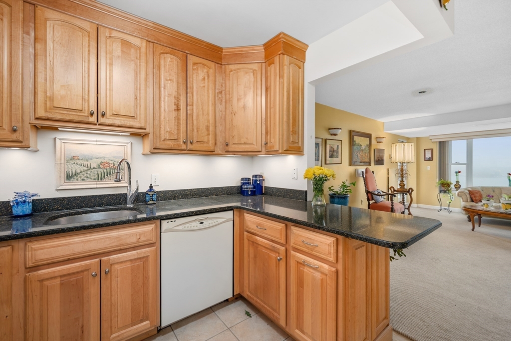 9 Park Avenue, Unit 705 Hull, MA 02045 - Photo 6 of 22 a kitchen with stainless steel appliances granite countertop a sink dishwasher stove and cabinets