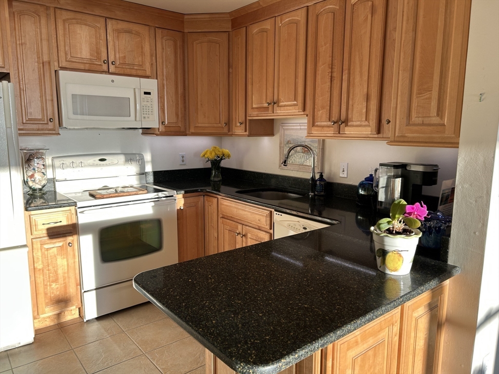 9 Park Avenue, Unit 705 Hull, MA 02045 - Photo 7 of 22 a kitchen with a sink a stove and cabinets