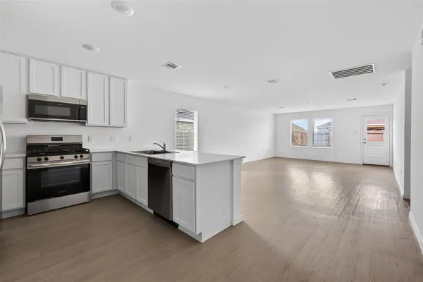 a kitchen with granite countertop a stove a sink and a refrigerator