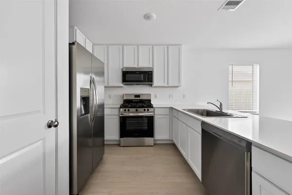 a kitchen with stainless steel appliances a refrigerator stove and sink