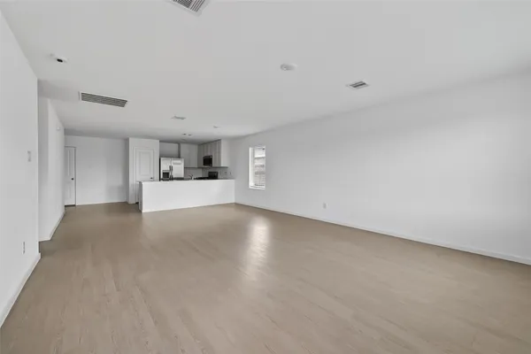 a view of empty room with kitchen