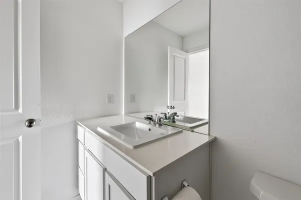 a bathroom with a sink vanity and toilet