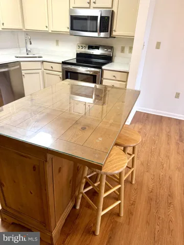 a kitchen with stainless steel appliances kitchen island granite countertop a sink a stove and cabinets