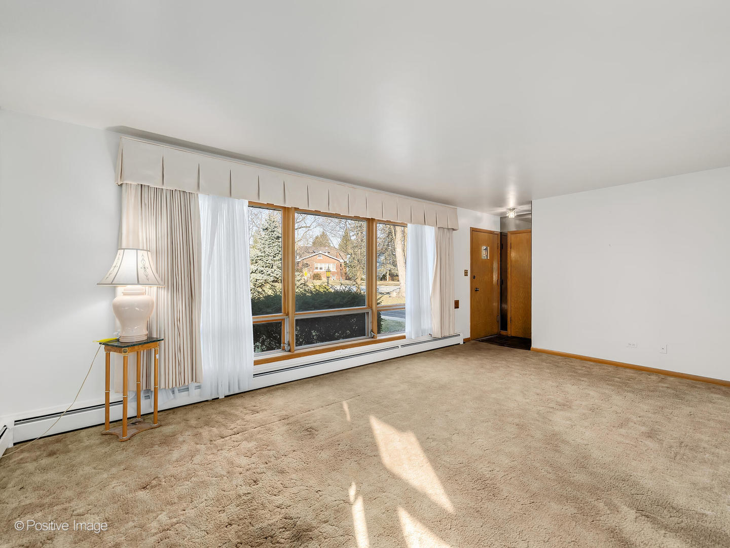365 Olmsted Road Riverside, IL 60546 - Photo 3 of 23 an empty room with a fireplace and large window