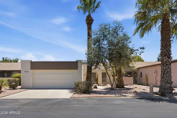 a front view of a house with a tree