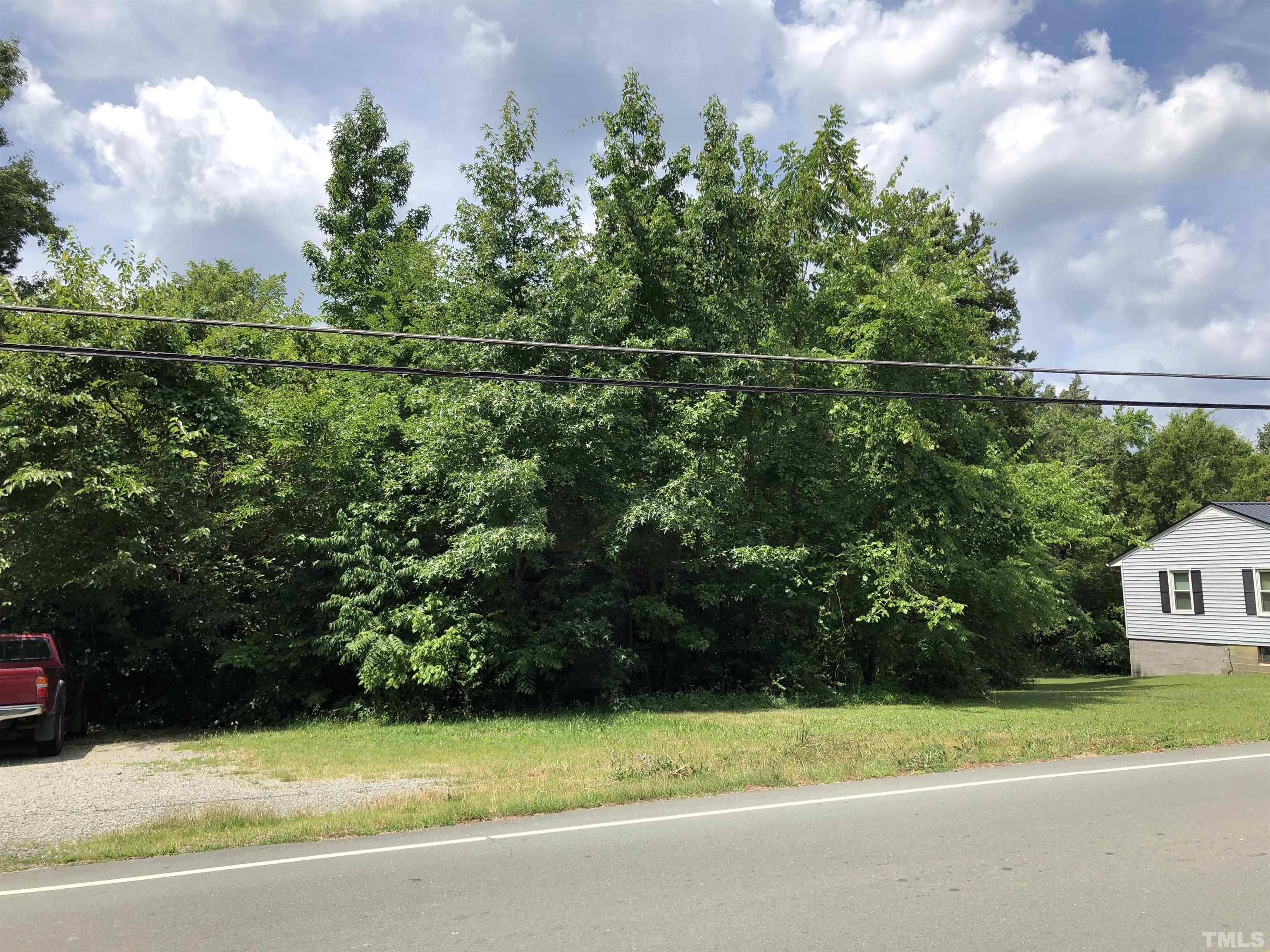 277 Cavel Chub Lake Road Roxboro, NC 27574 - Photo 23 of 24 a view of a house with a backyard and a tree