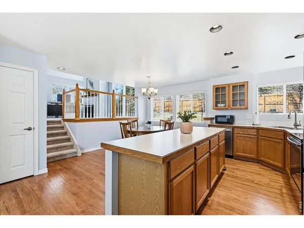 a kitchen with stainless steel appliances granite countertop a sink and a wooden floors
