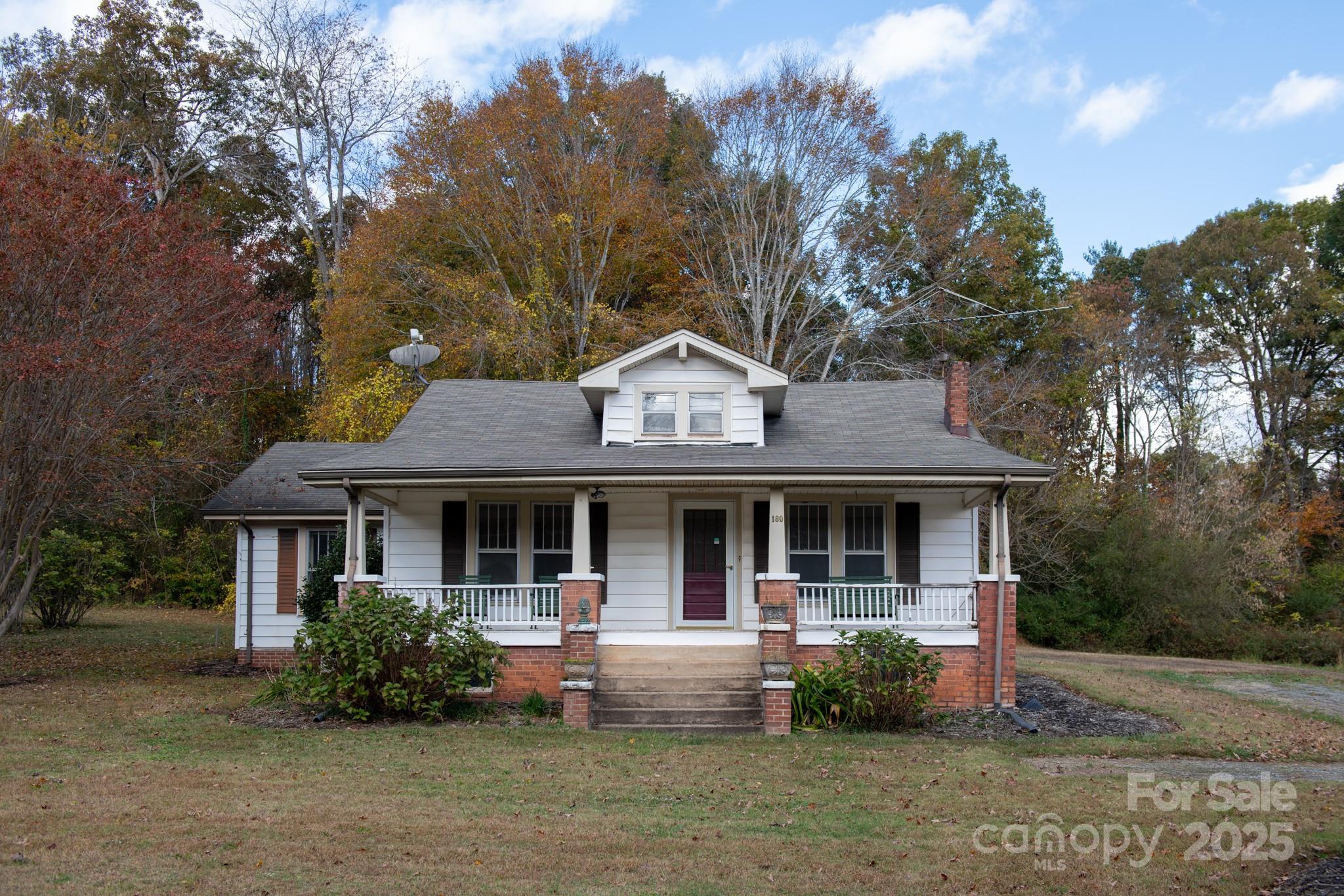4541 Hartland Road Lenoir, NC 28645 - Photo 34 of 40 a view of a white house with large windows and a large tree