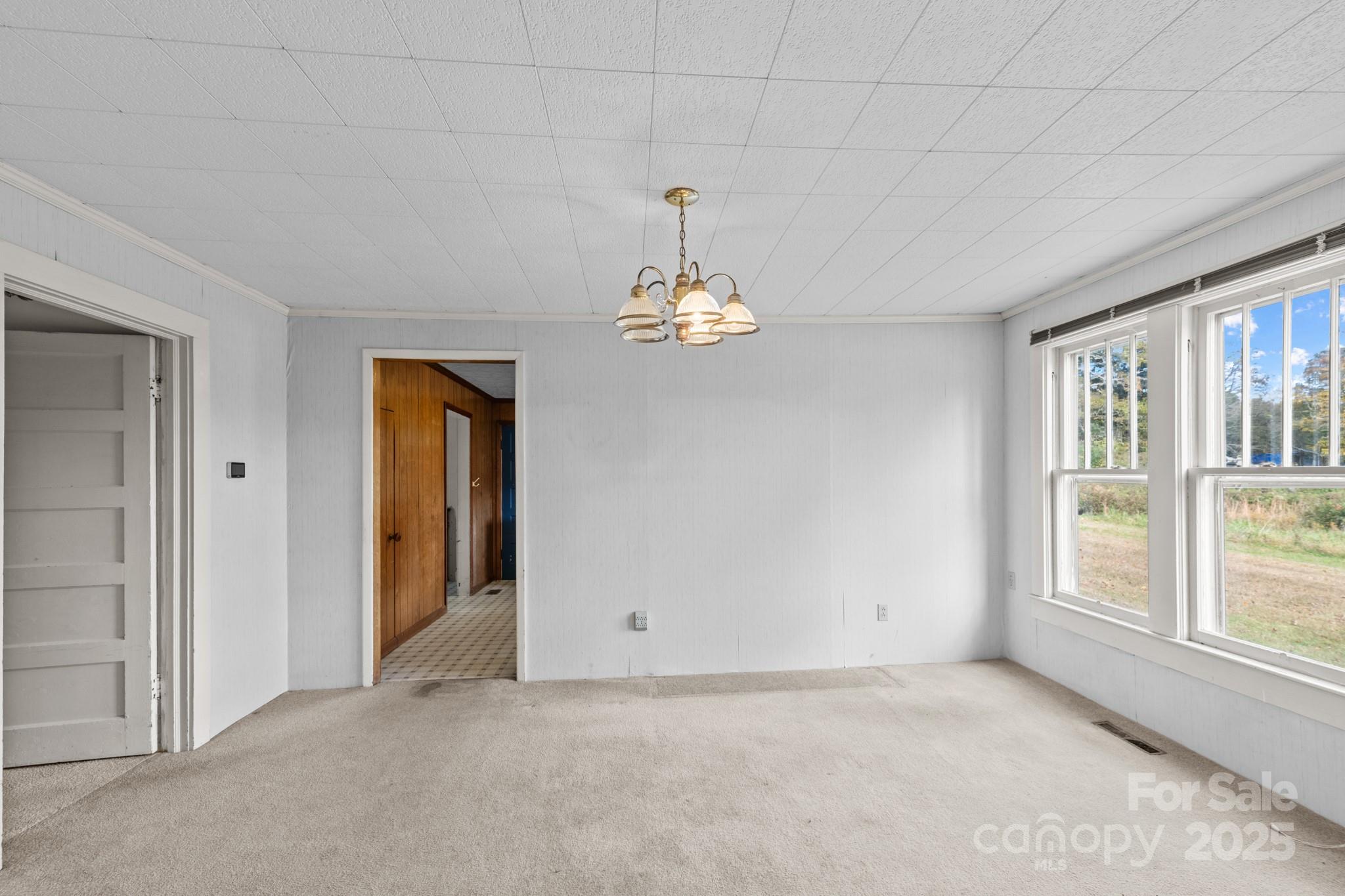 4541 Hartland Road Lenoir, NC 28645 - Photo 6 of 40 an empty room that has a chandelier fan and windows