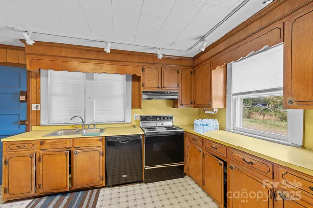 a kitchen with stainless steel appliances granite countertop a stove a sink and a refrigerator
