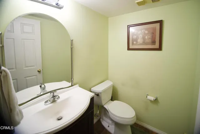 a bathroom with a sink mirror and toilet