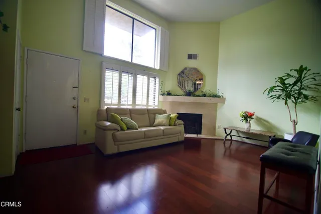 a living room with furniture a fireplace and a potted plant