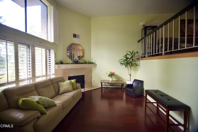a living room with furniture fireplace and a large window