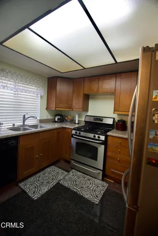 a kitchen with a sink a stove cabinets and a window