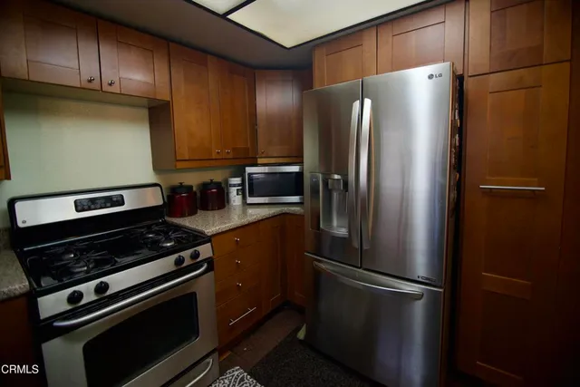 a kitchen with metallic refrigerator and cabinets