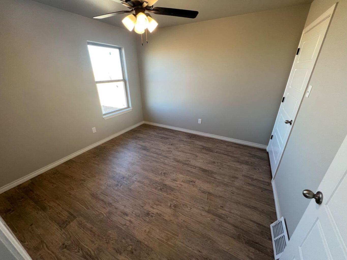 1407 17th Street, Unit A Shallowater, TX 79363 - Photo 11 of 18 a view of a room with wooden floor and chandelier