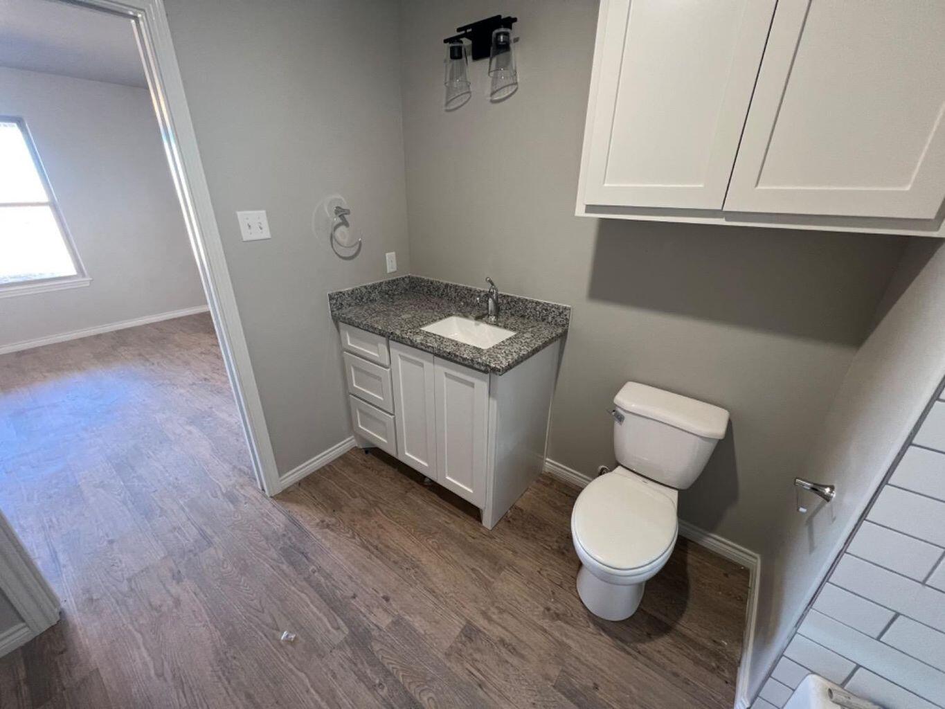 1407 17th Street, Unit A Shallowater, TX 79363 - Photo 16 of 18 a bathroom with a toilet and a sink