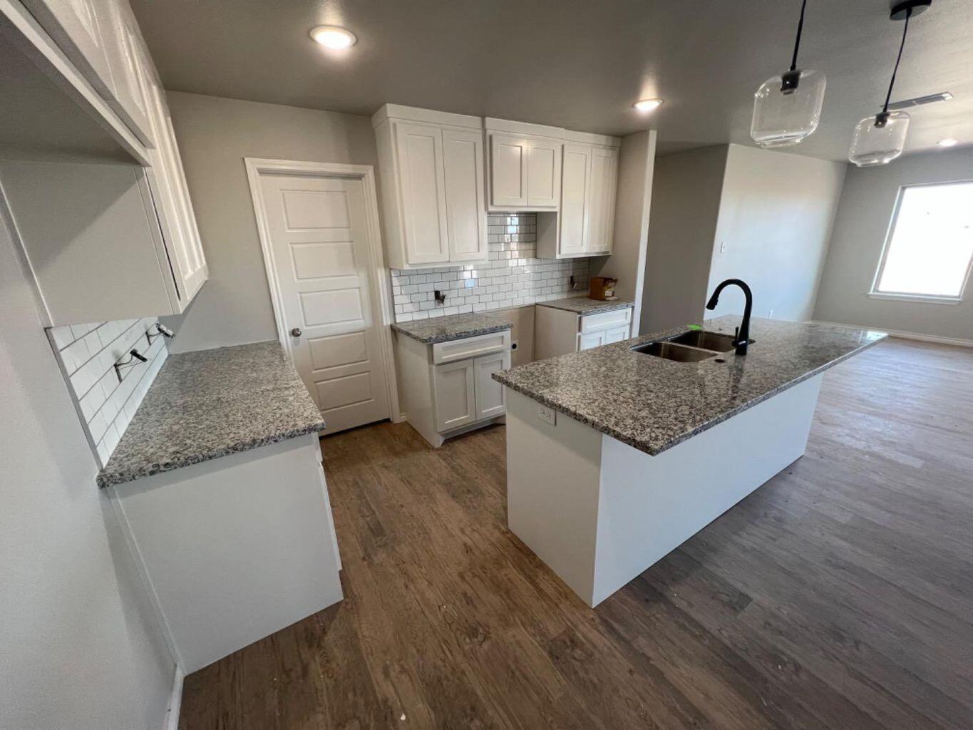 1407 17th Street, Unit A Shallowater, TX 79363 - Photo 7 of 18 a kitchen with granite countertop a sink stove and refrigerator