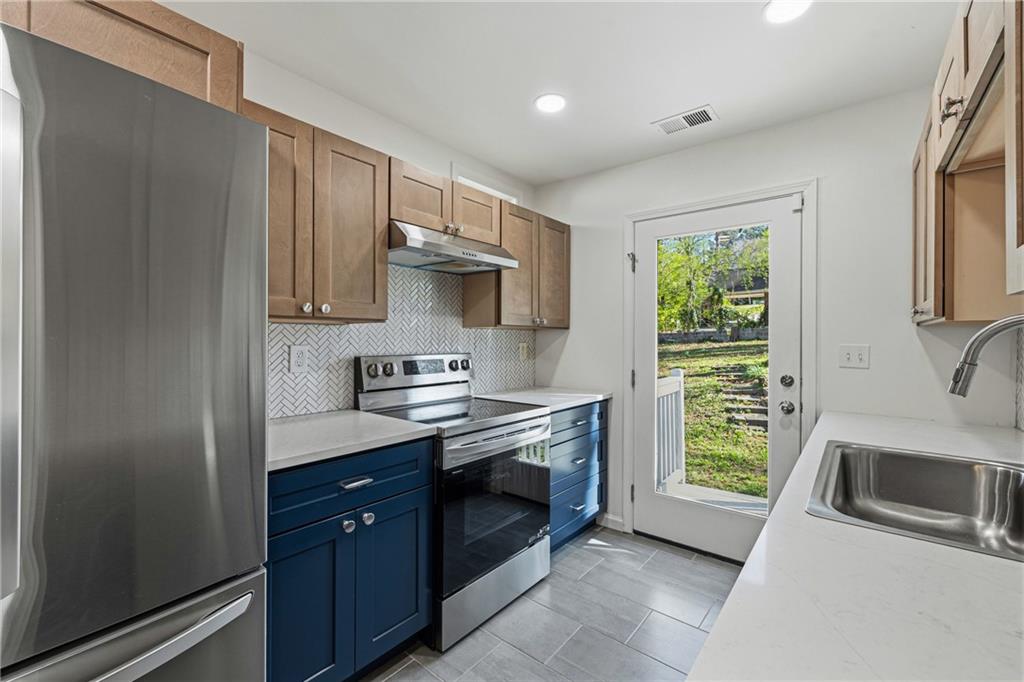 2583 Joyce Avenue Decatur, GA 30032 - Photo 6 of 30 a kitchen with stainless steel appliances granite countertop a sink stove and refrigerator