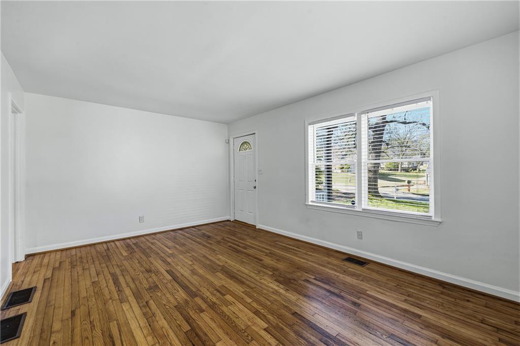 2583 Joyce Avenue Decatur, GA 30032 - Photo 8 of 30 a view of an empty room with wooden floor and a window
