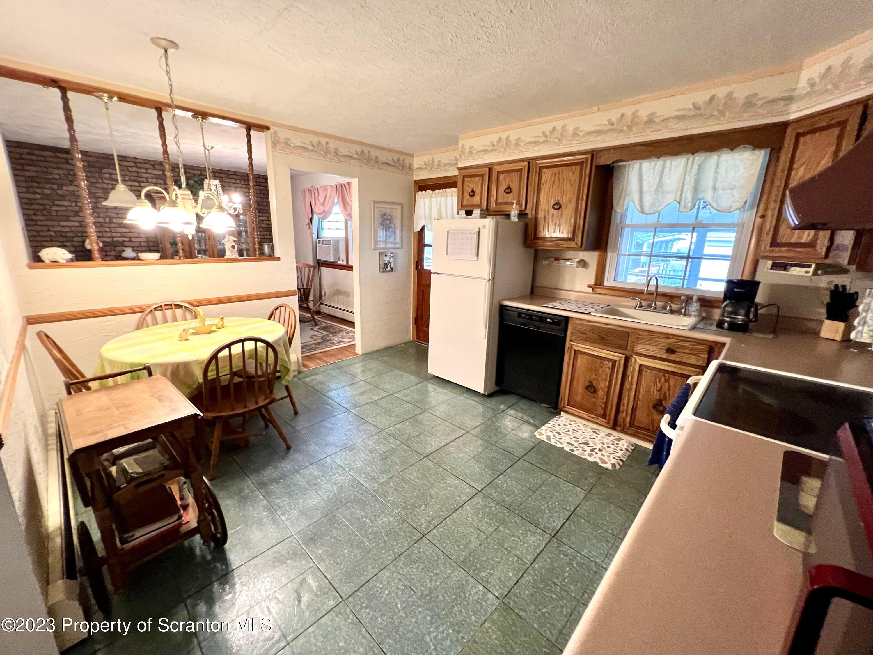 218 Jackson Street Olyphant, PA 18447 - Photo 7 of 46 a kitchen with stainless steel appliances kitchen island granite countertop a refrigerator and a stove