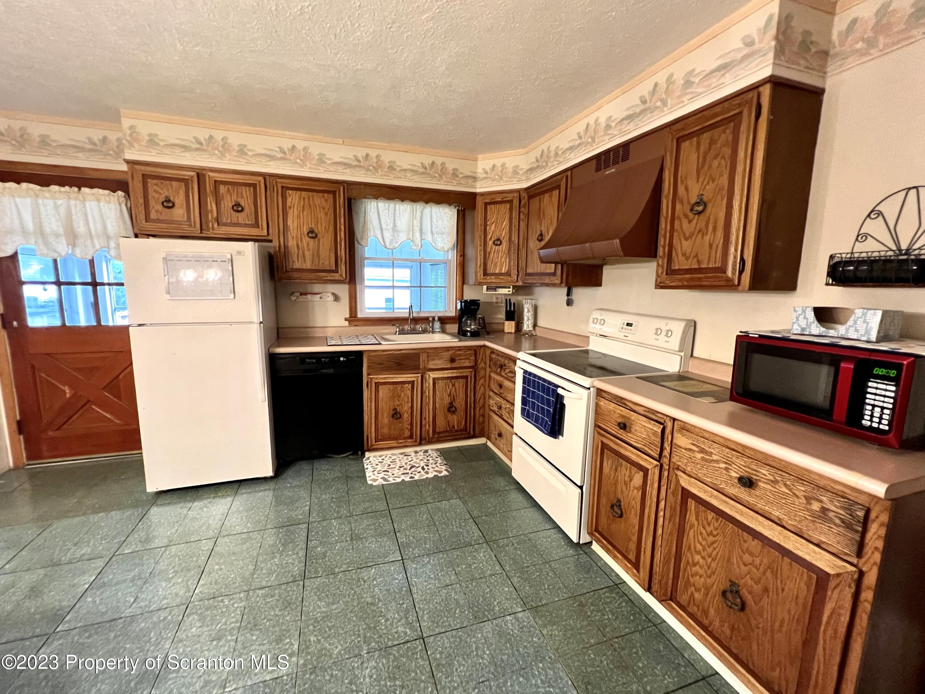 218 Jackson Street Olyphant, PA 18447 - Photo 8 of 46 a kitchen with stainless steel appliances granite countertop a stove top oven a sink a counter top space and cabinets