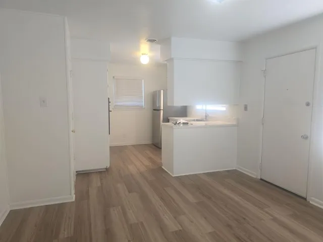 a view of empty room with wooden floor