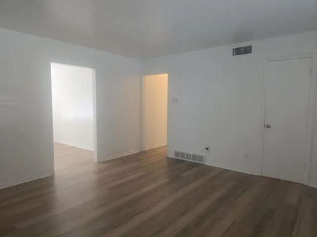 an empty room with wooden floor and closet