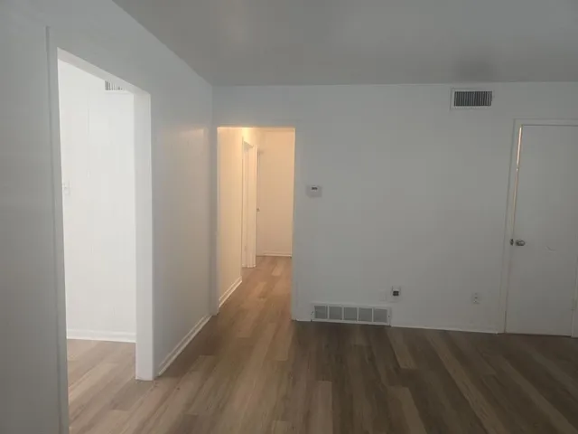 a view of a room with wooden floor