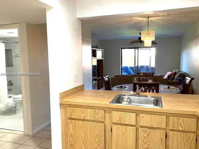 a living room with a table chairs and a refrigerator