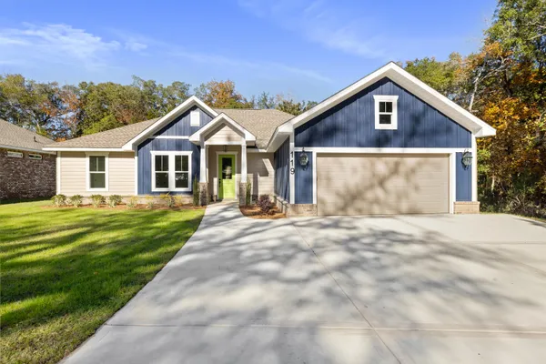 a front view of a house with a garden and patio