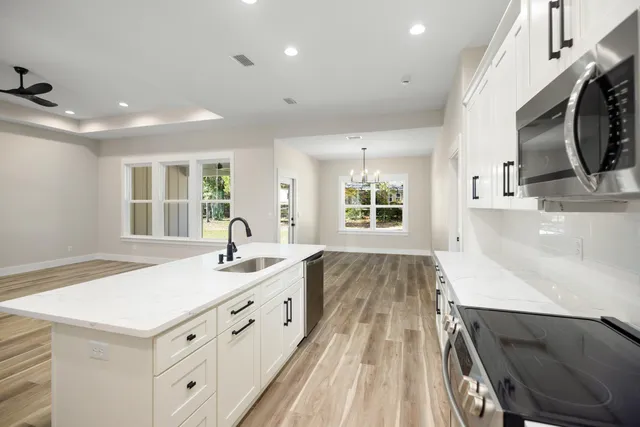 a kitchen with kitchen island a sink stainless steel appliances and cabinets