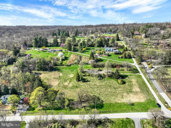 an aerial view of residential houses with outdoor space and trees