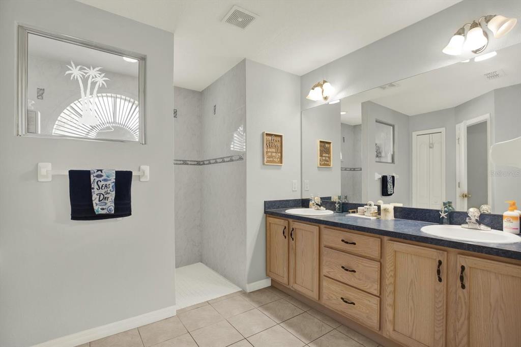 5220 Kirkwood Avenue Spring Hill, FL 34608 - Photo 15 of 39 a spacious bathroom with a double vanity sink and a mirror