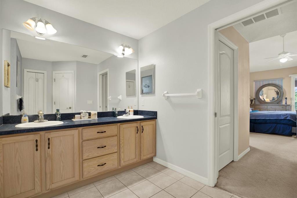 5220 Kirkwood Avenue Spring Hill, FL 34608 - Photo 16 of 39 a spacious bathroom with a granite countertop sink and a mirror