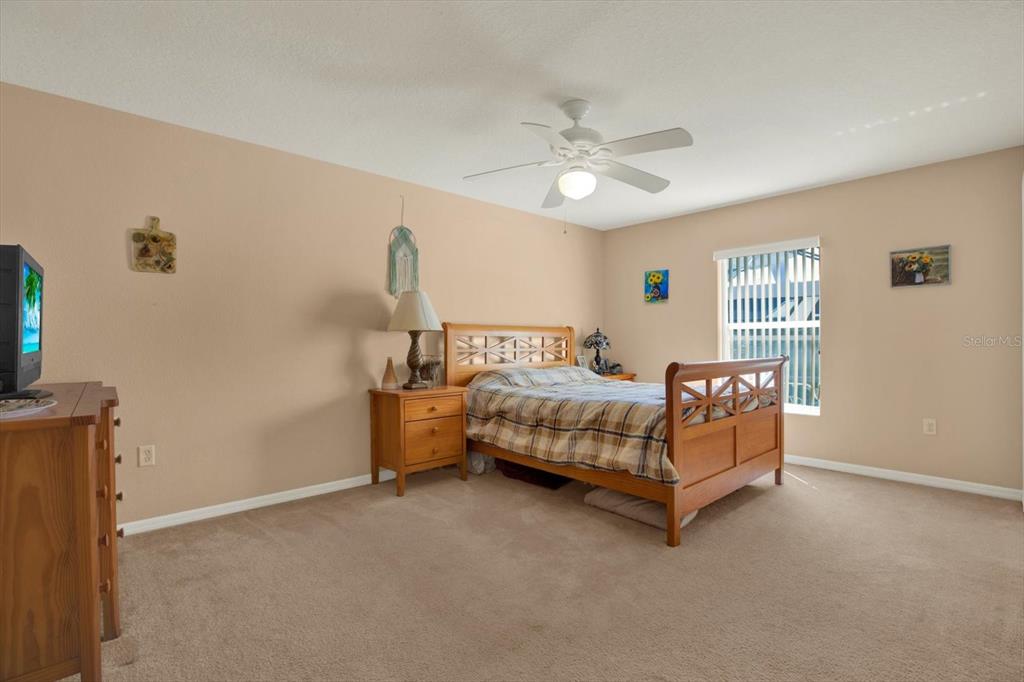 5220 Kirkwood Avenue Spring Hill, FL 34608 - Photo 18 of 39 a bedroom with a bed and a chandelier