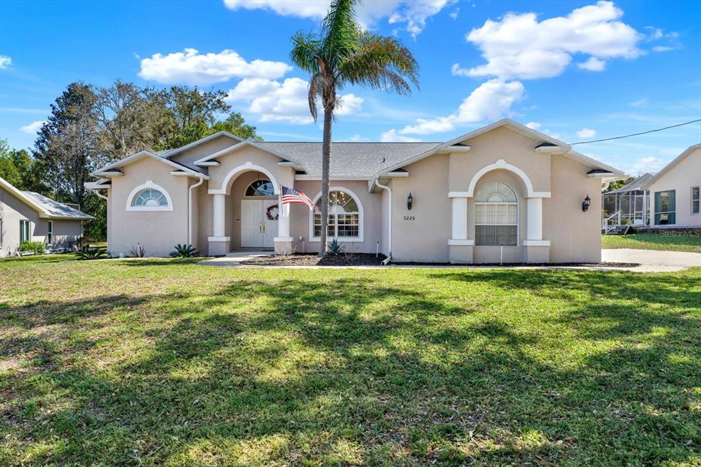 5220 Kirkwood Avenue Spring Hill, FL 34608 - Photo 2 of 39 a front view of house with yard and green space