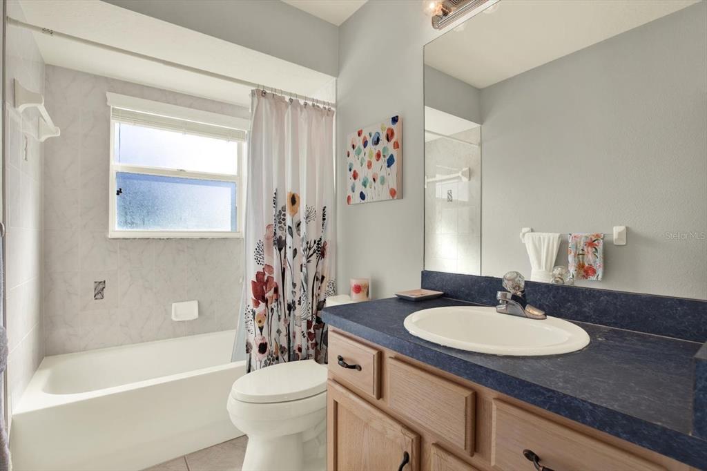 5220 Kirkwood Avenue Spring Hill, FL 34608 - Photo 25 of 39 a bathroom with a sink toilet a mirror and shower