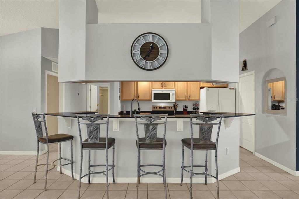 5220 Kirkwood Avenue Spring Hill, FL 34608 - Photo 6 of 39 a kitchen with stainless steel appliances granite countertop a table chairs and a refrigerator