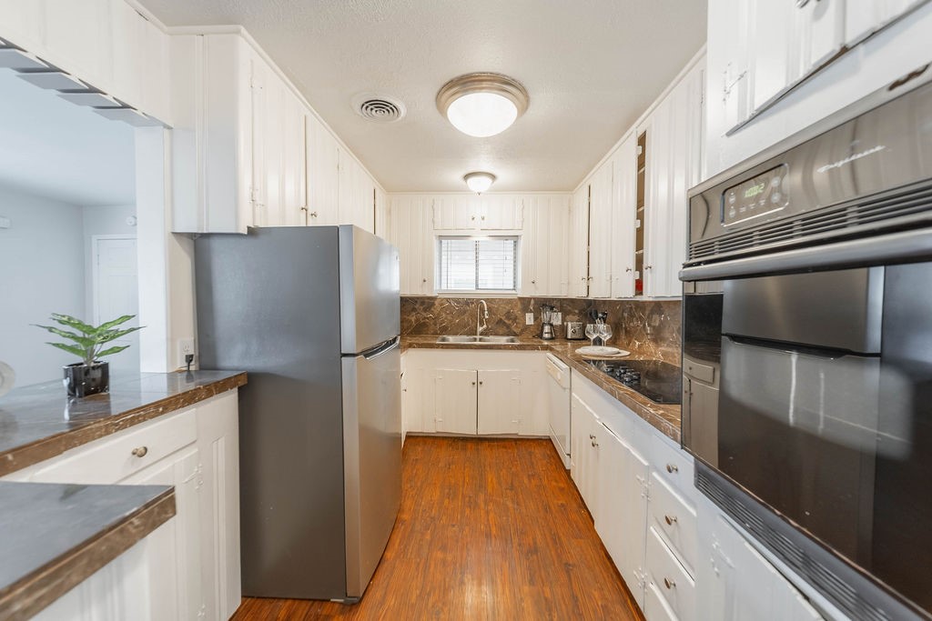 4723 Merwin Street Houston, TX 77027 - Photo 9 of 29 a kitchen with a refrigerator sink and white cabinets