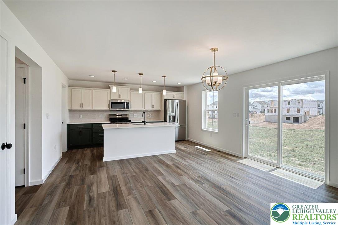 253 West Center Road, Unit LOT 123 Northampton, PA 18067 - Photo 6 of 16 a view of kitchen with granite countertop refrigerator oven a sink and white cabinets with wooden floor
