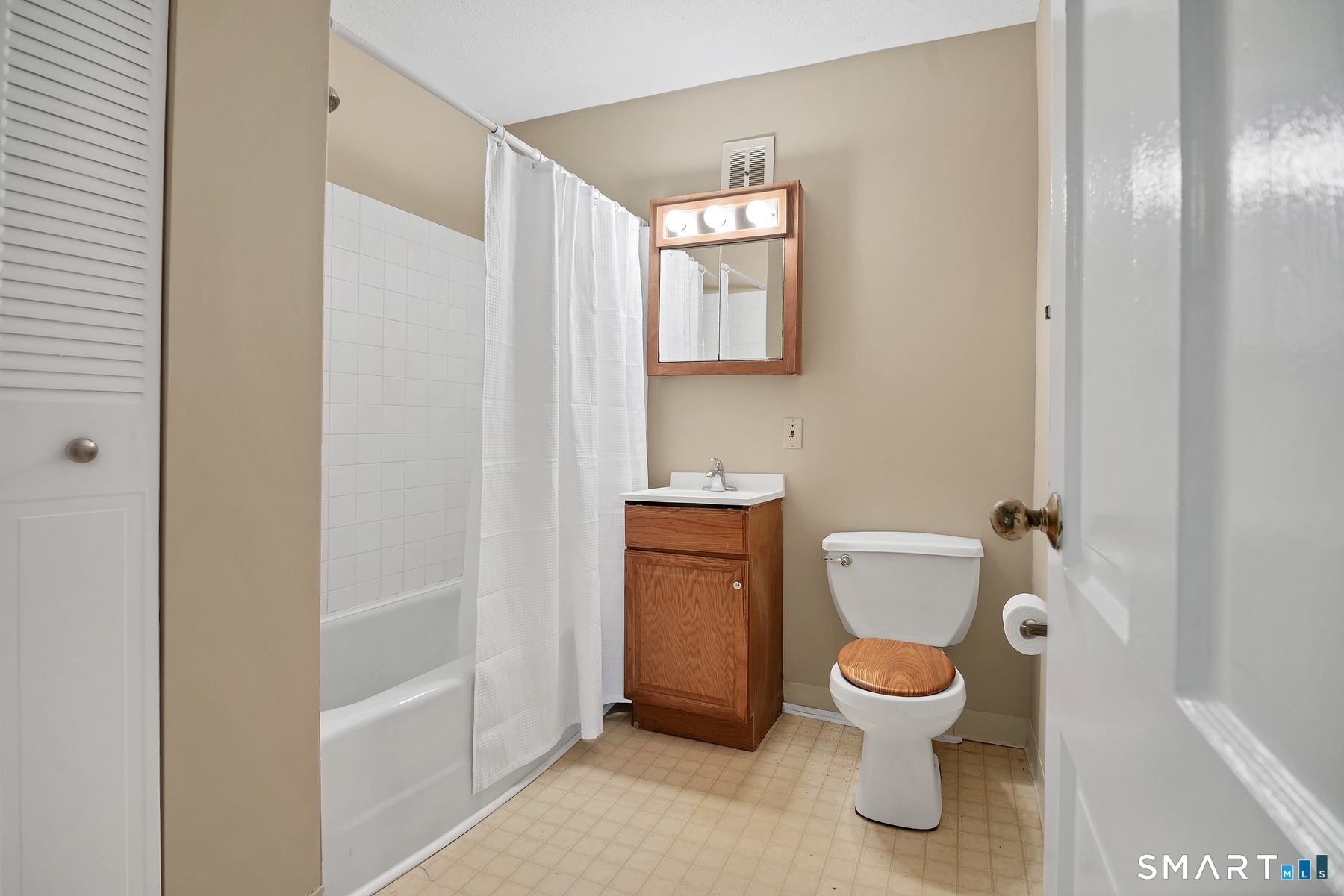 111 Niles Hill Road, Unit E New London, CT 06320 - Photo 24 of 26 a white toilet sitting next to a bathroom sink and a mirror