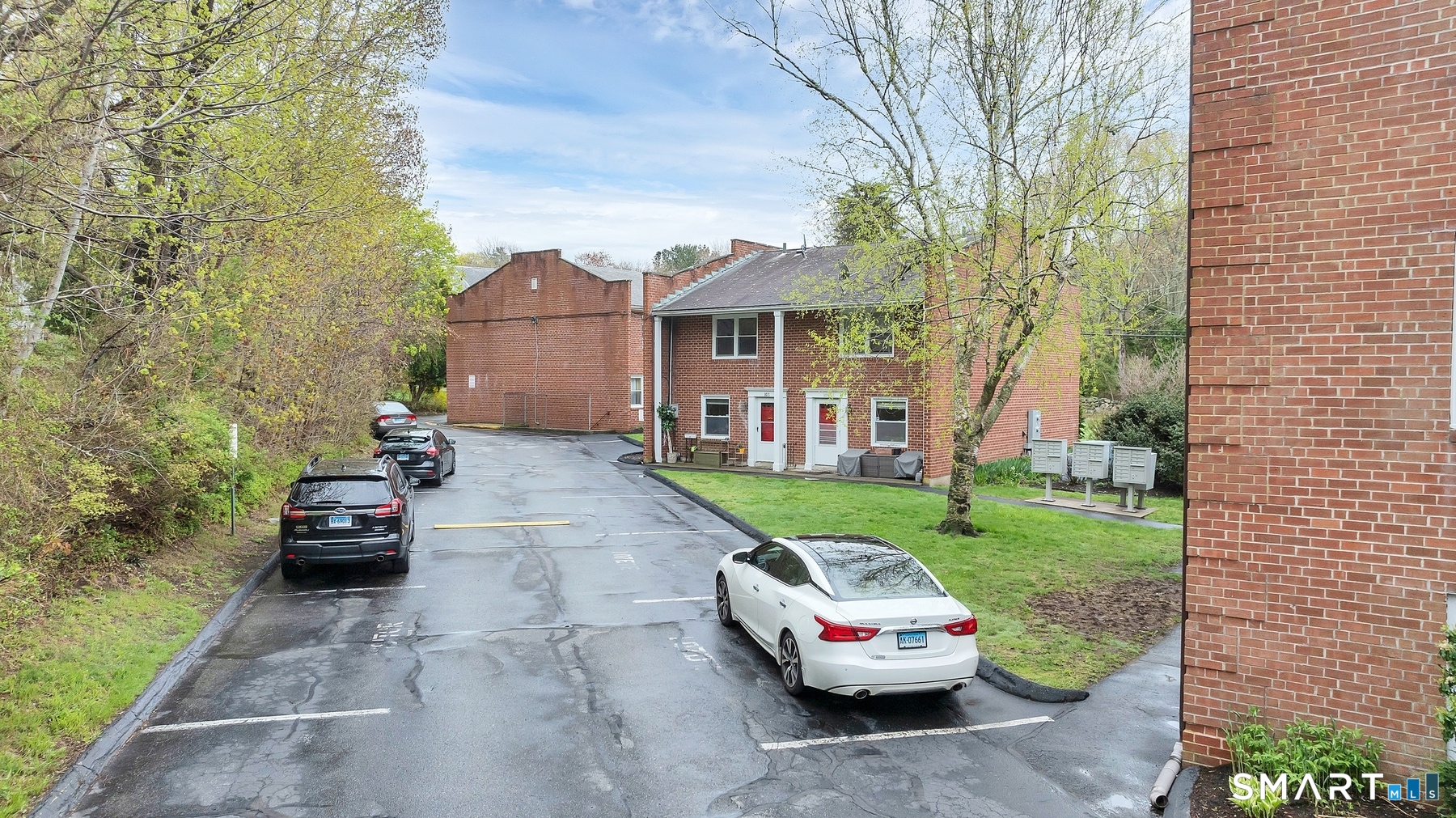111 Niles Hill Road, Unit E New London, CT 06320 - Photo 8 of 26 a car parked in front of a brick house with a small yard