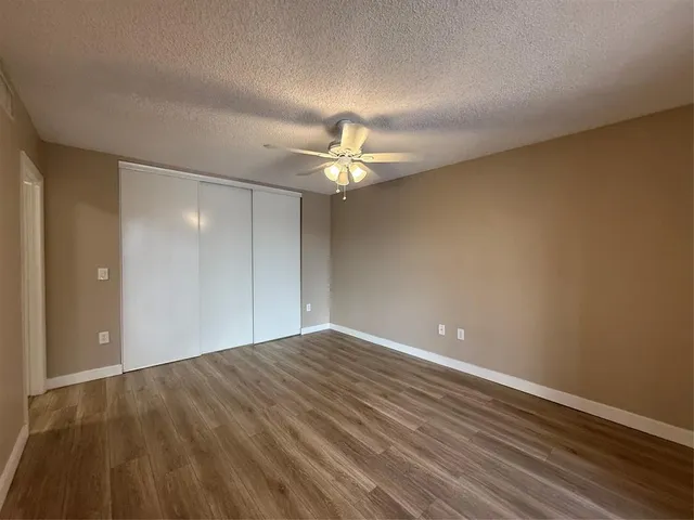a bathroom with a granite countertop shower sink vanity and toilet