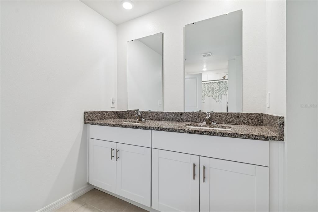4530 Cozy Condor Court Bartow, FL 33830 - Photo 15 of 35 a bathroom with a granite countertop sink and a mirror