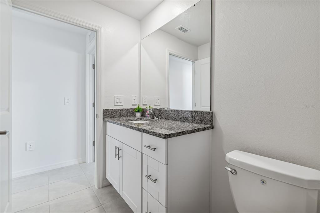 4530 Cozy Condor Court Bartow, FL 33830 - Photo 22 of 35 a bathroom with a granite countertop sink and a toilet