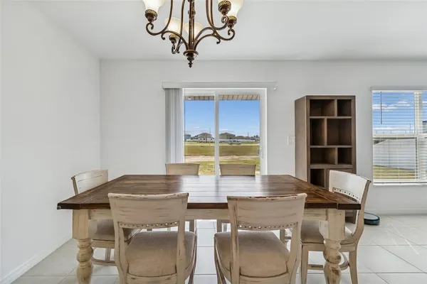 a view of a dining room with furniture a chandelier and wooden floor