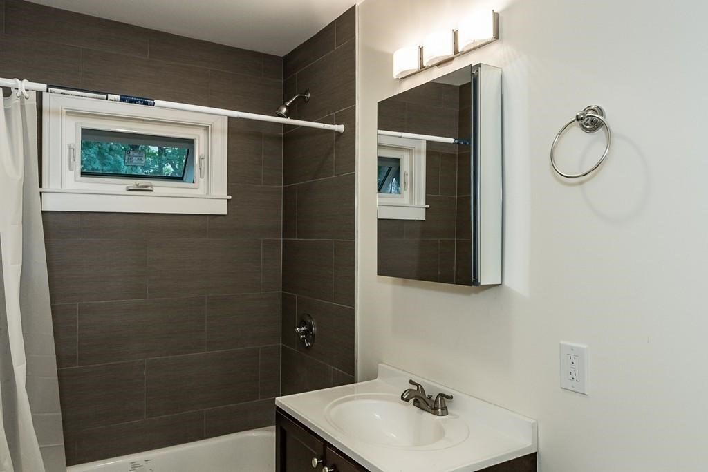 51 Leamington Road, Unit 1 Boston, MA 02135 - Photo 11 of 12 a bathroom with a sink mirror and shower