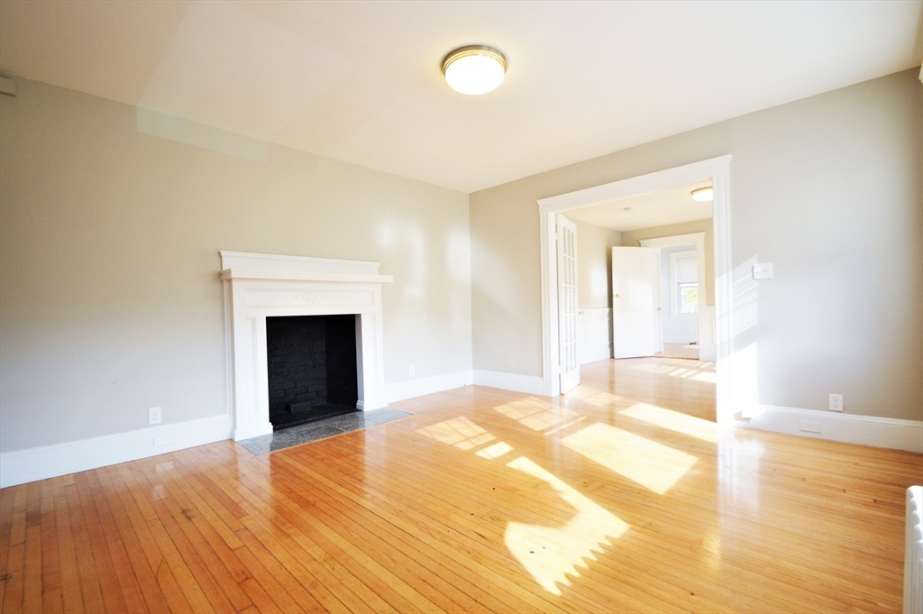 51 Leamington Road, Unit 1 Boston, MA 02135 - Photo 3 of 12 a view of an empty room with wooden floor and a window